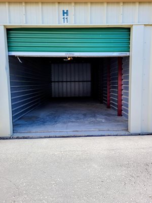 A garage door with a green roller shutter and a sign that says H 11.